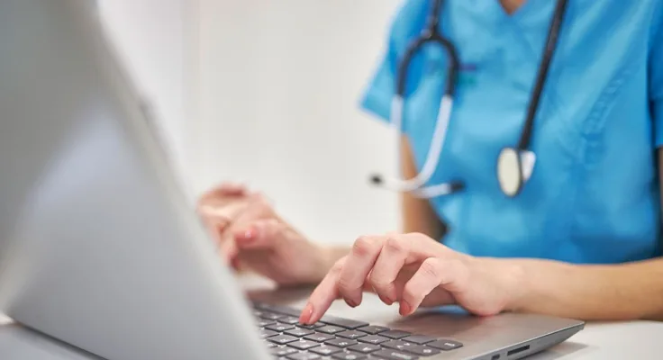 Nurse working in nursing informatics on computer