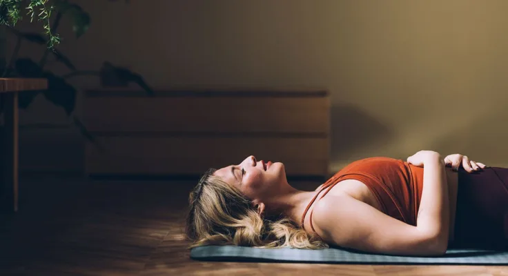 Woman laying on floor engaging in self care