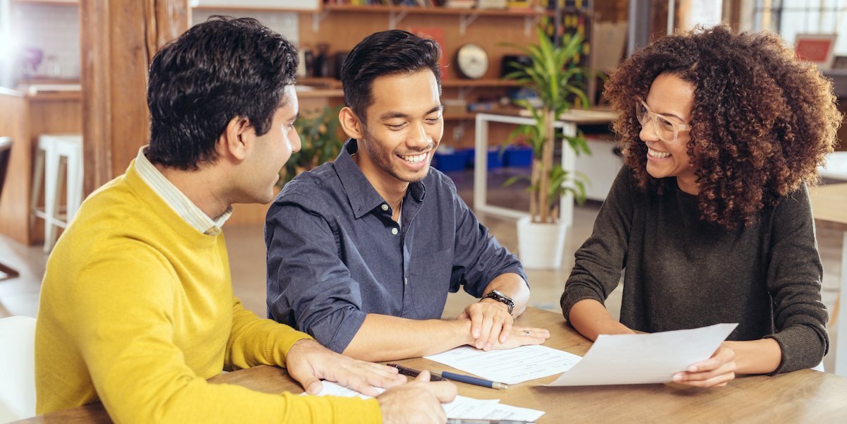 A couple working with their real estate agent to draft an offer for a home purchase.