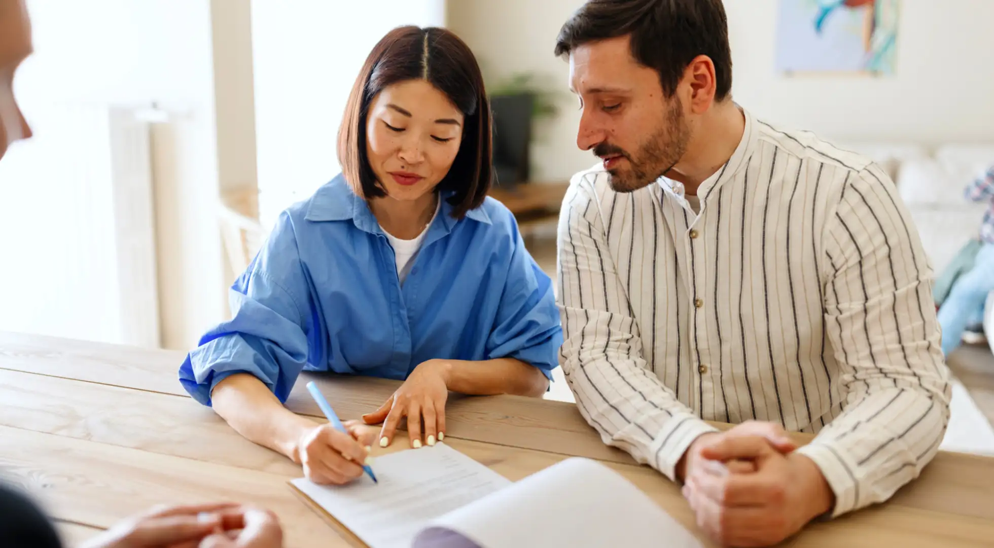 A couple sitting at a table, reviewing a mortgage document with an advisor.