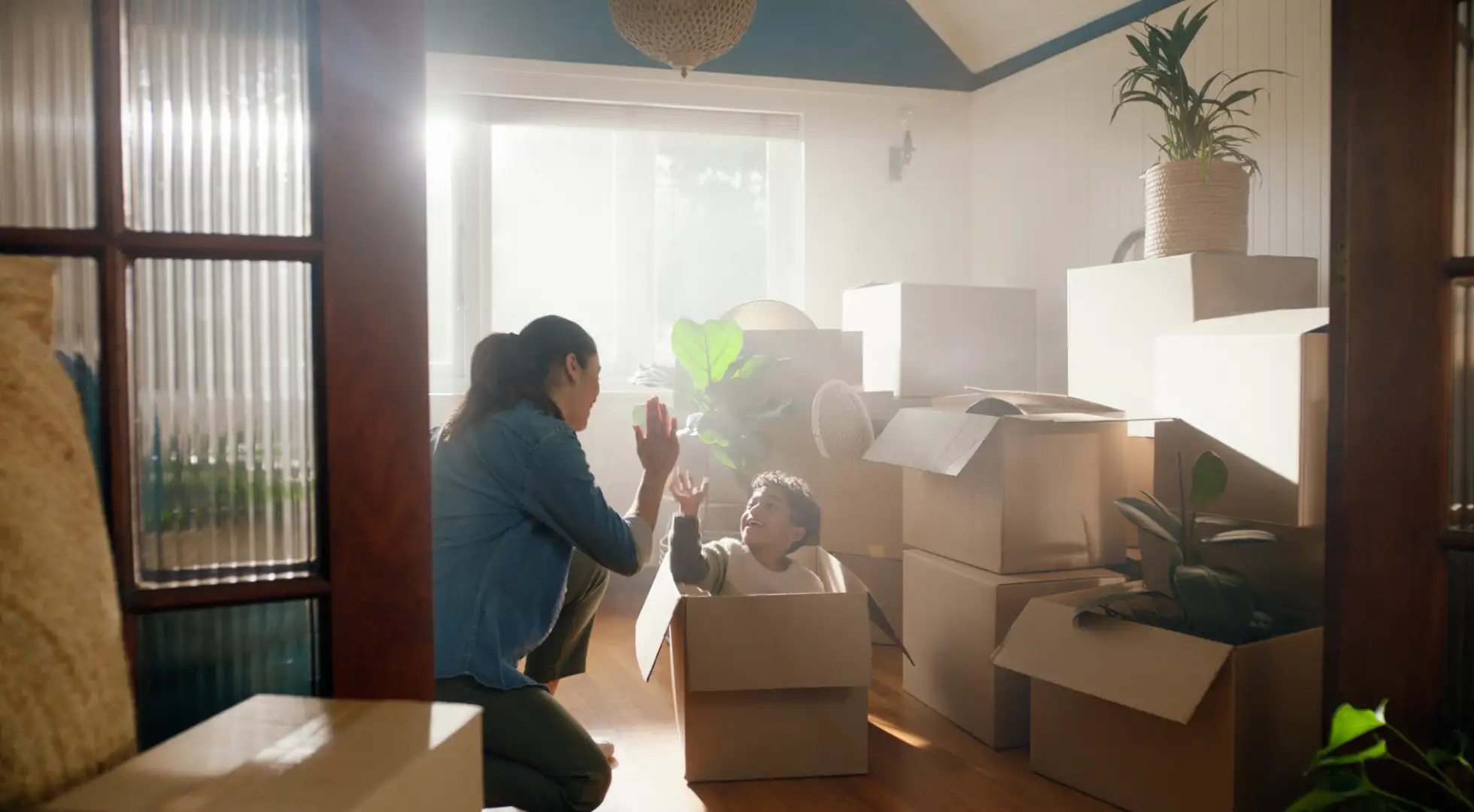 Mother and son unpacking boxes in their new home