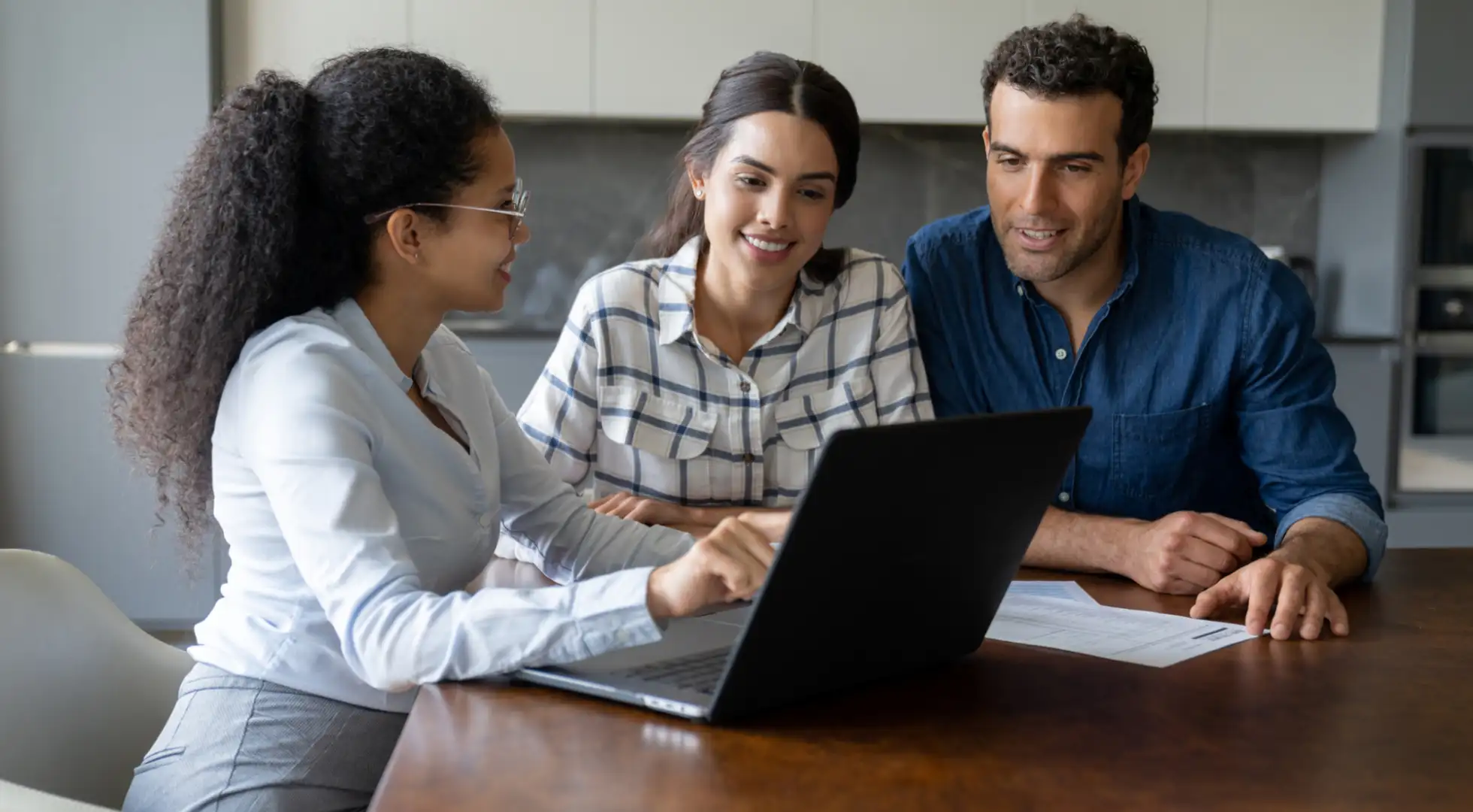 Couple sitting with mortgage loan officer talking about refinancing.