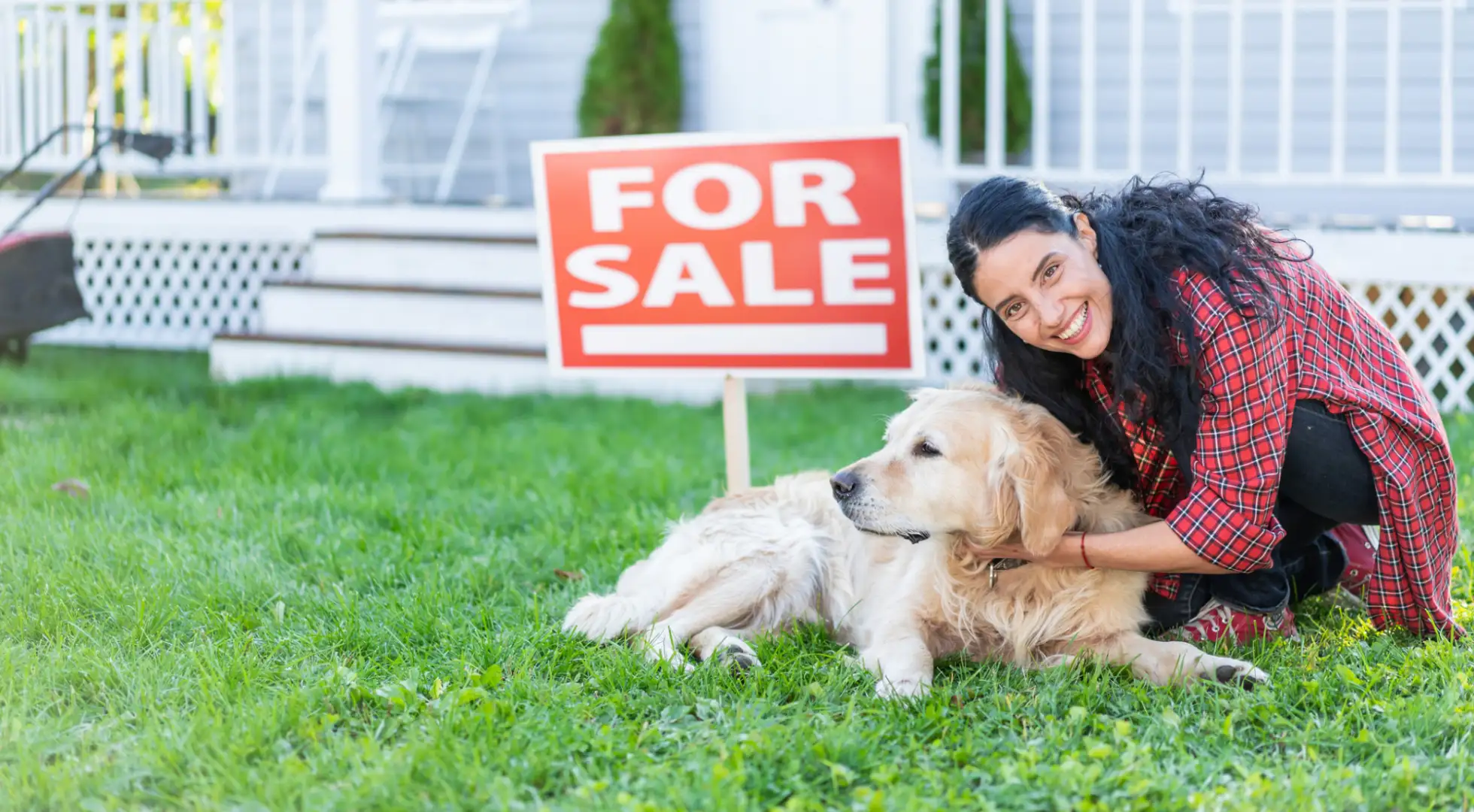 A woman pets her dog in front of home she has listed for sale.