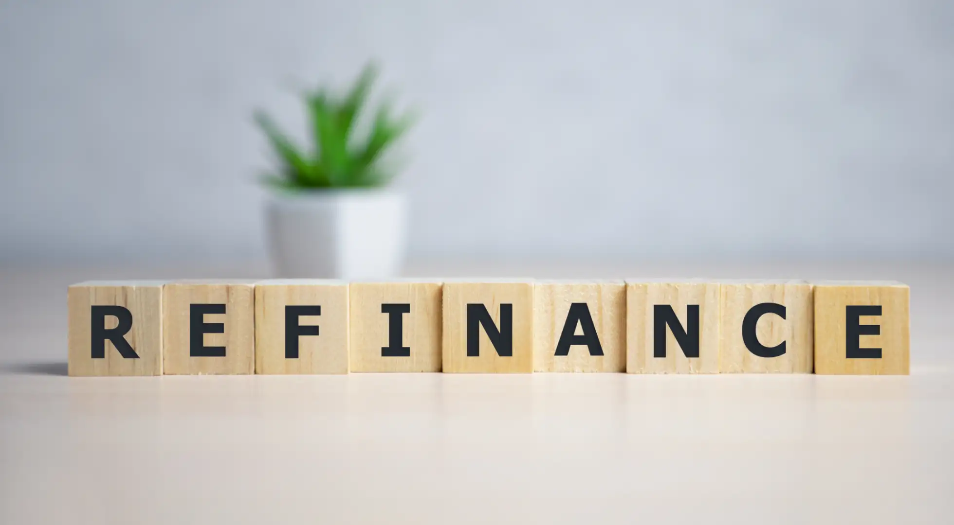 Scrabble tiles spell out the word "refinance."