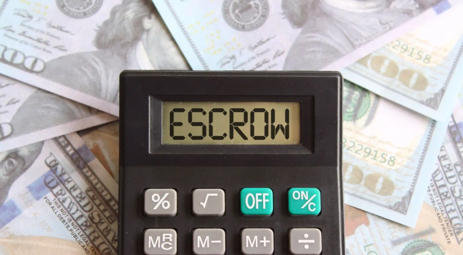 What is Mortgage Escrow? 'Escrow' displayed on a calculator screen on top of a stack of money