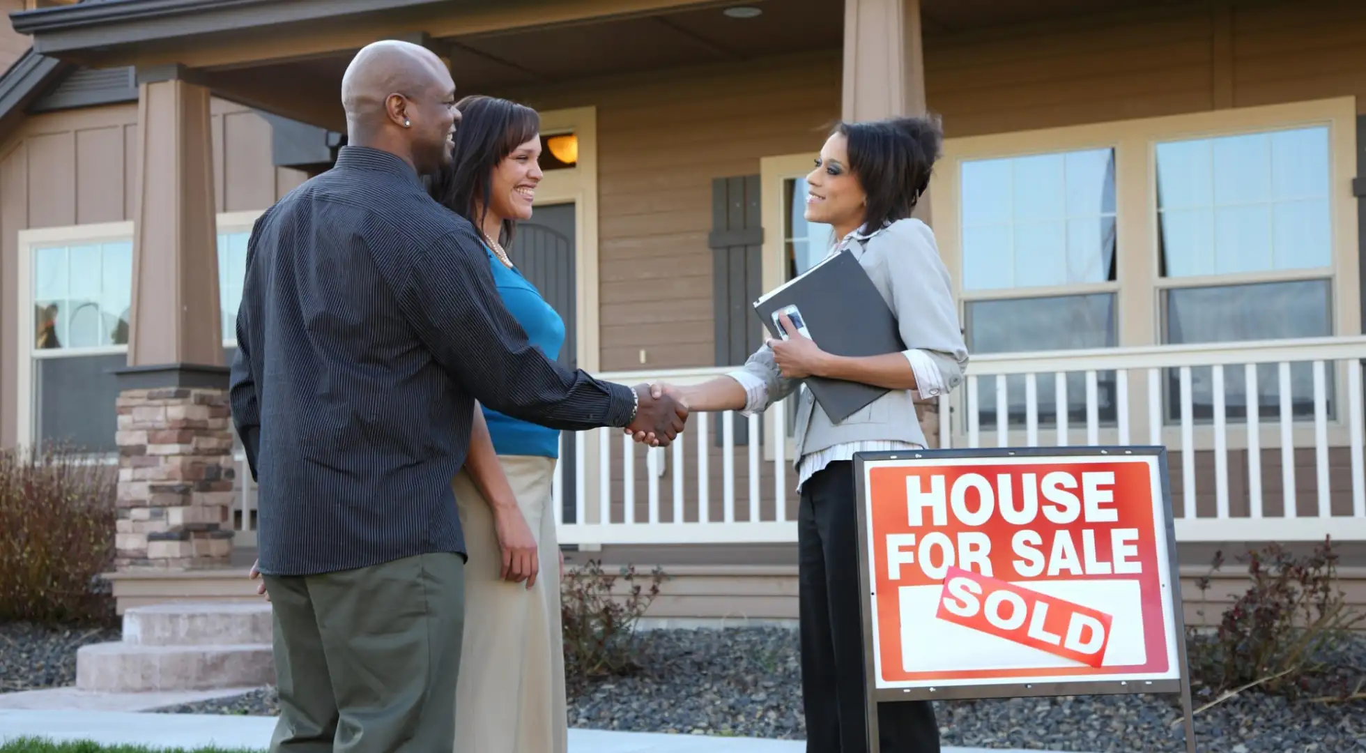 Making an Offer on a House: Step-By-Step Guide for First-Time Buyers Couple shakes realtor's hand after buying house.