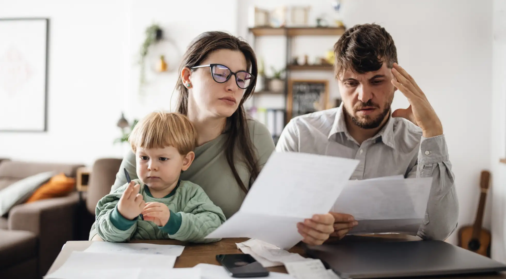 Young family stressed out while looking at paperwork.