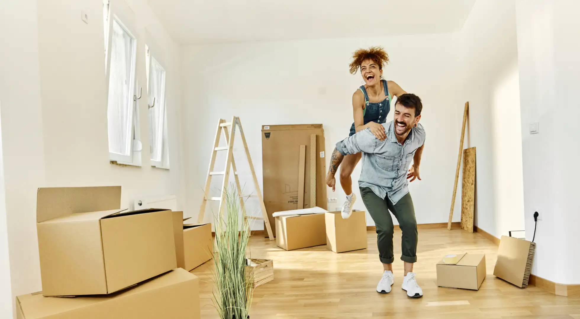 excited couple in their new home with moving boxes