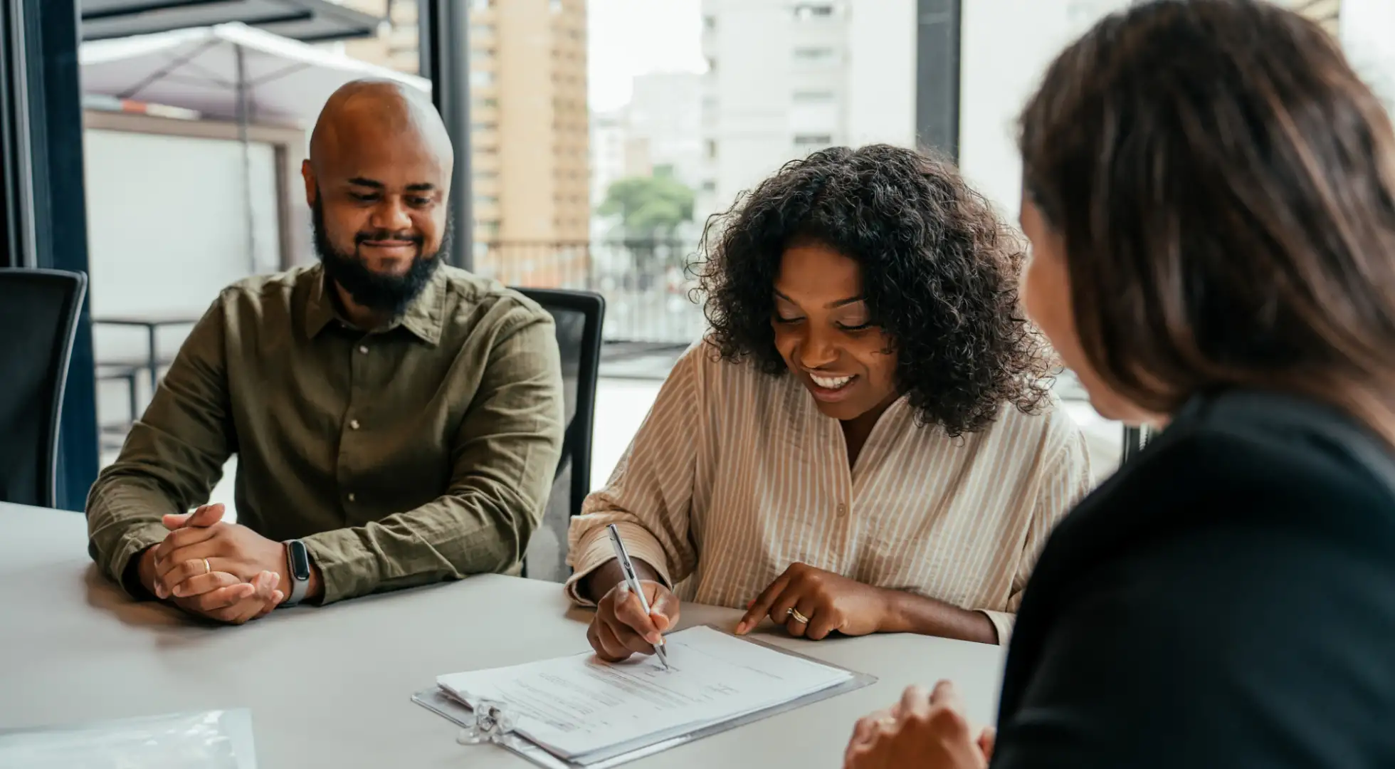 homebuying couple signing paperwork at closing