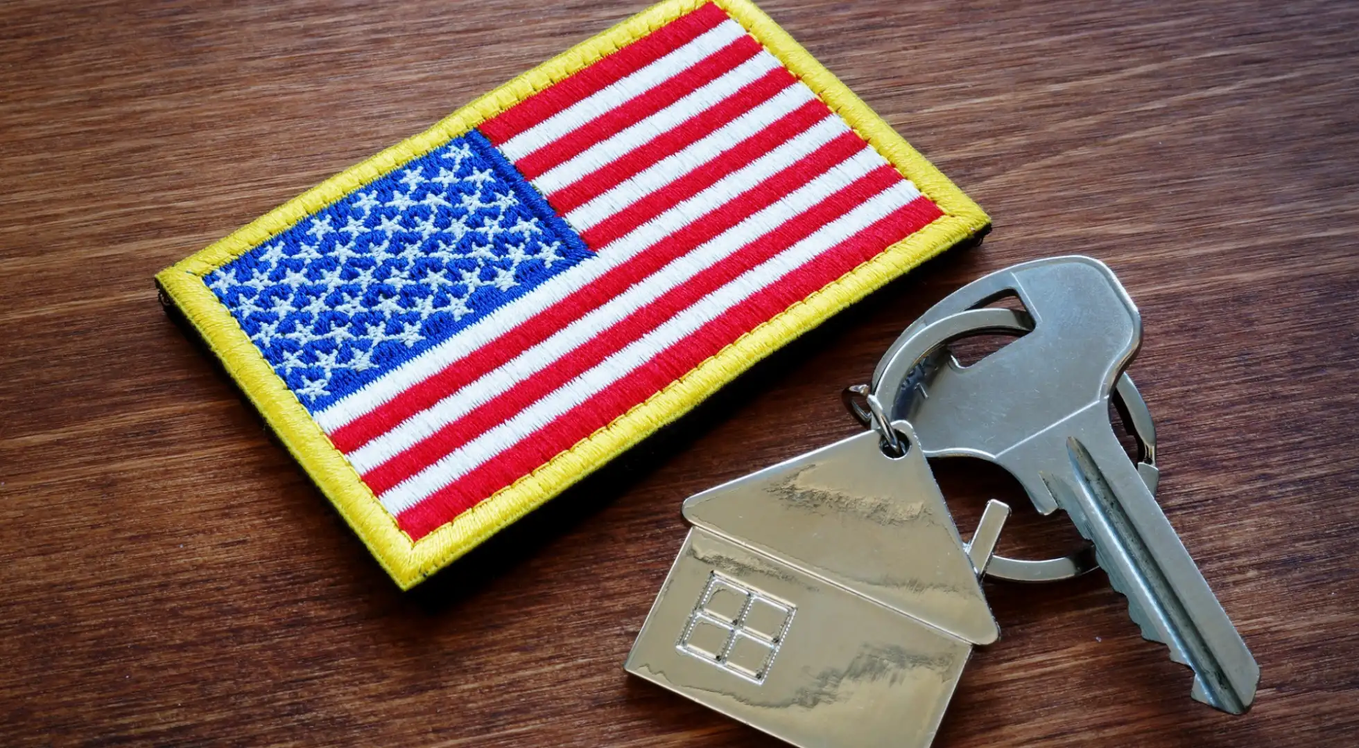 American flag patch next to a key with a keychain of a home