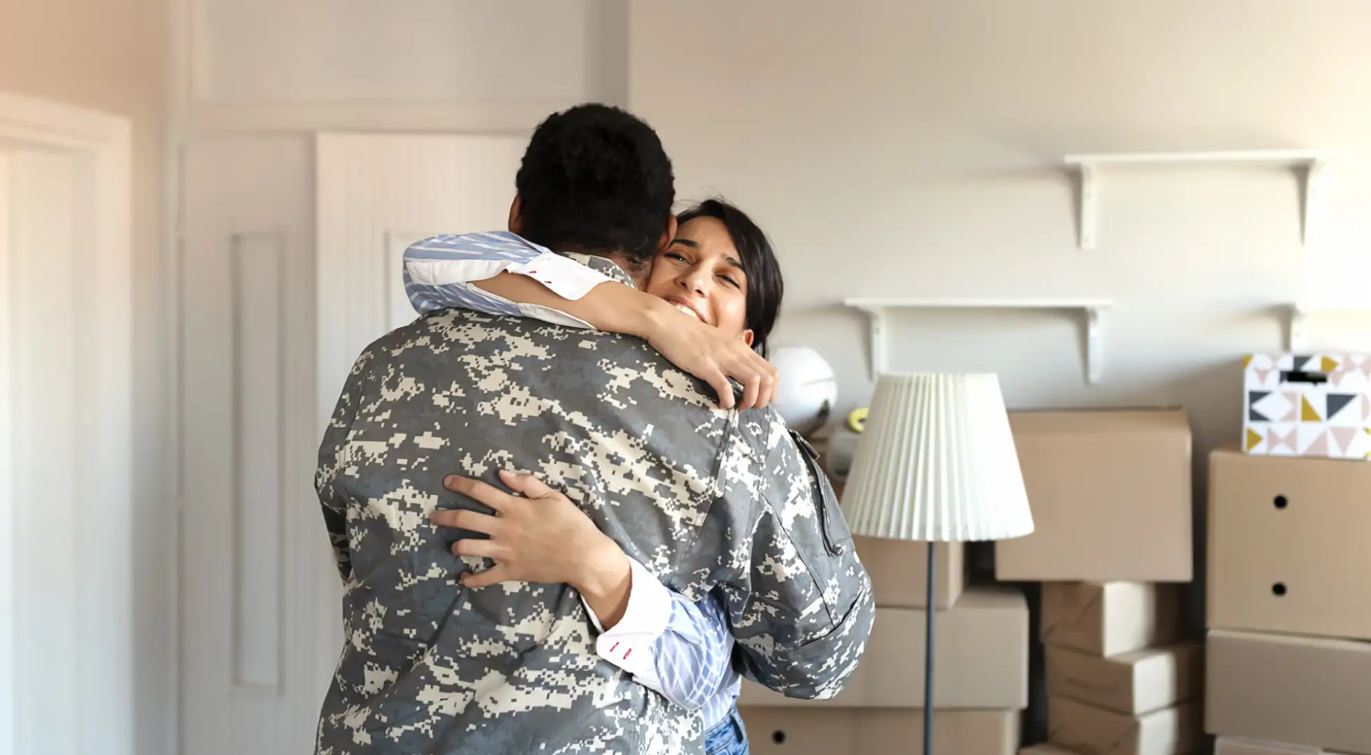 soldier hugging his wife as they move into their new home