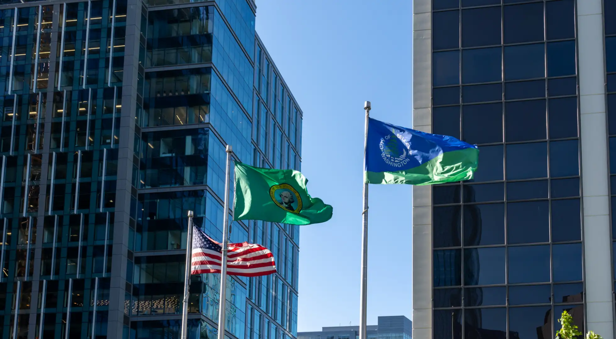us, washington, and bellevue flags in front of downtown buildings: down payment assistance washington