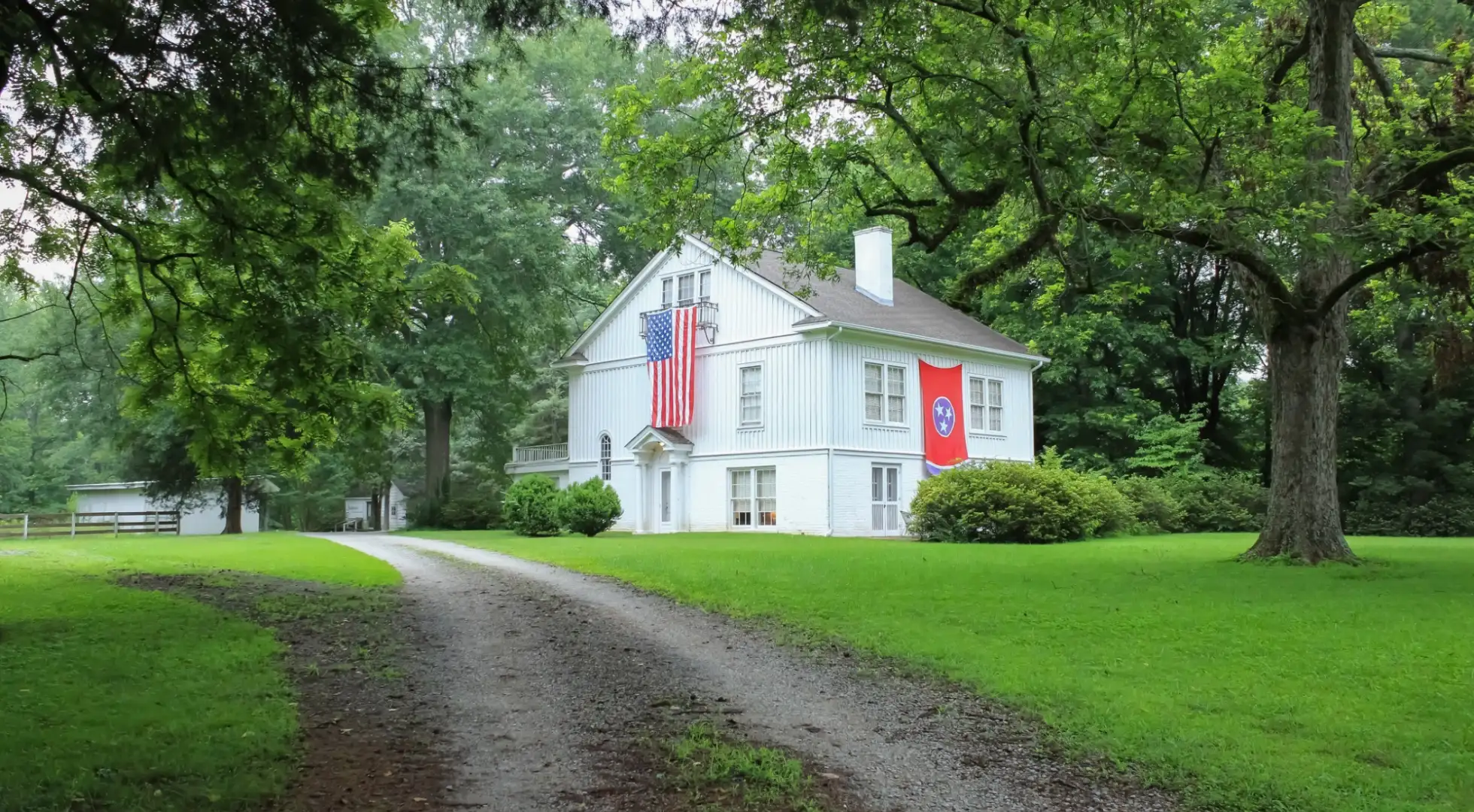 rural home in tennessee with both the US and state flags: down payment assistance