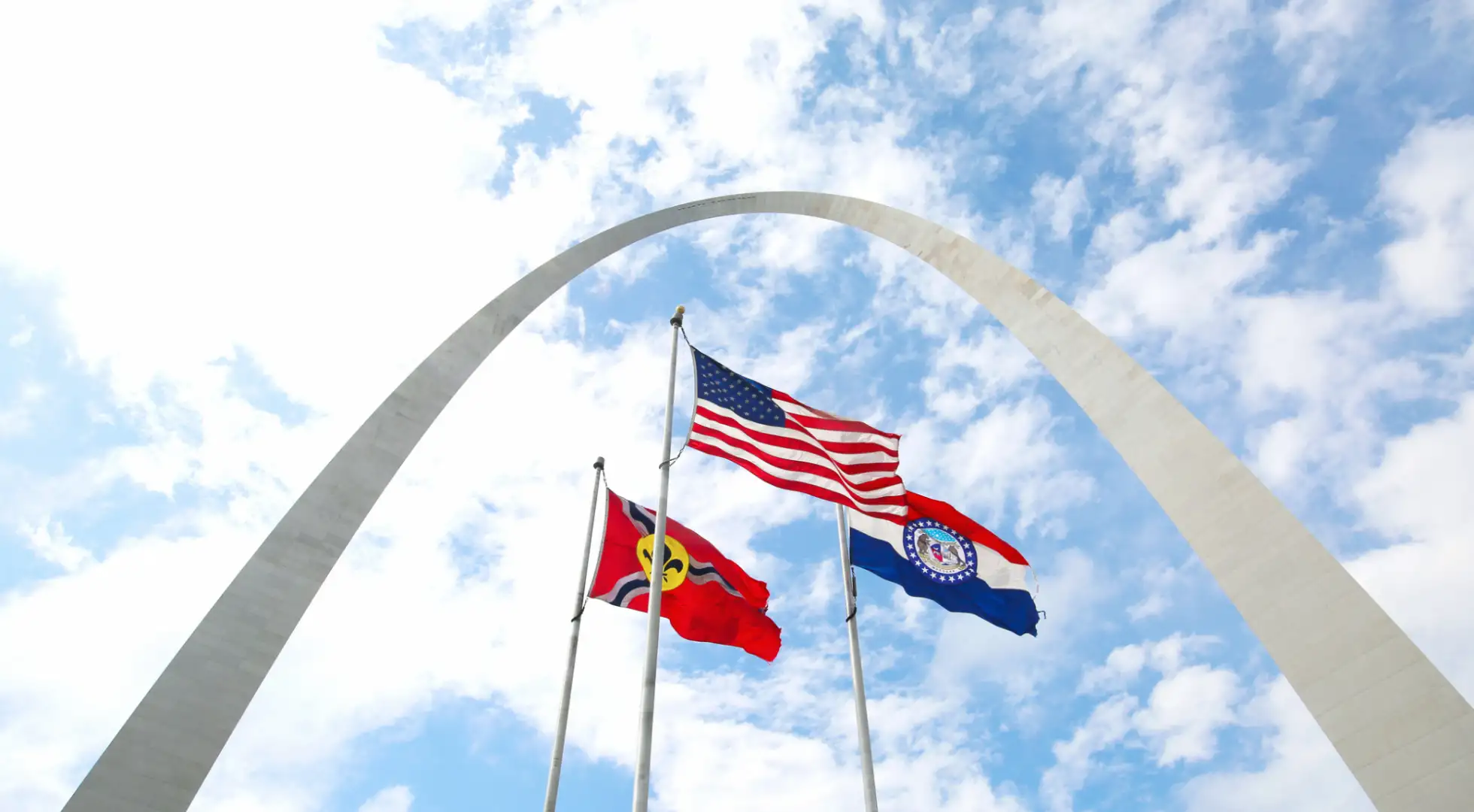 us, missouri, and st louis flags in front of the gateway arch: down payment assistance missouri