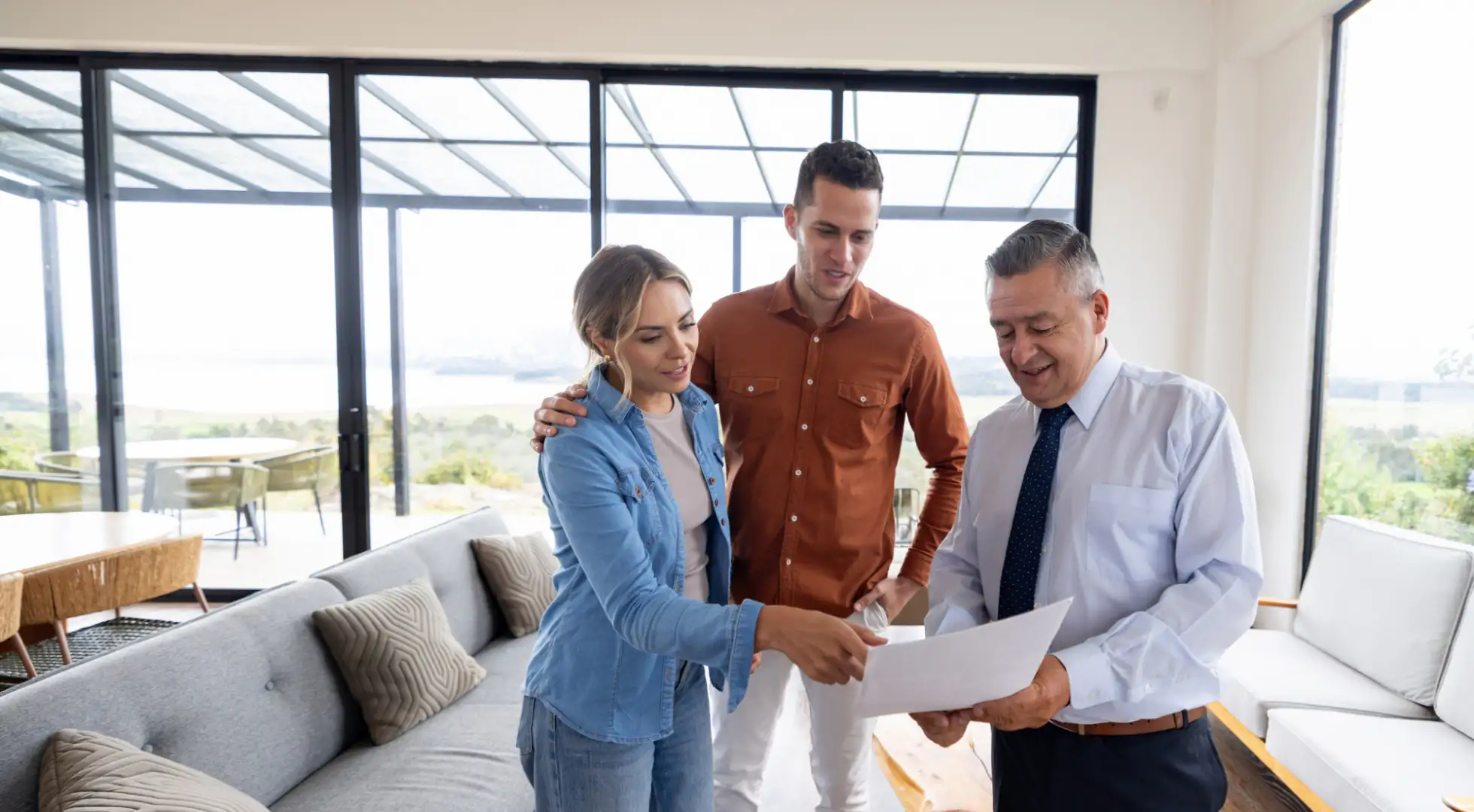 couple looking over a contract with their real estate agent in a high-rise condo