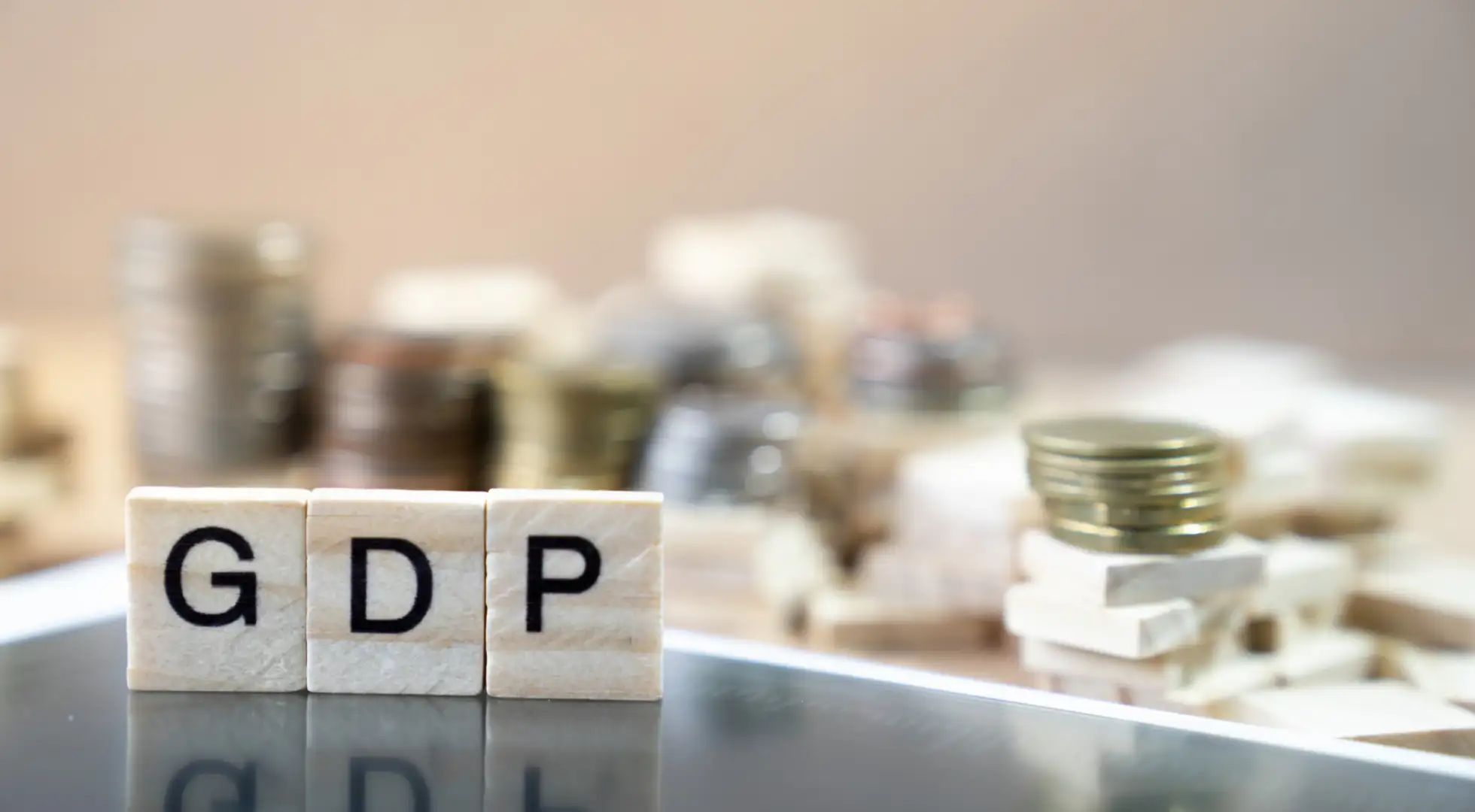 "GDP" spelled out with Scrabble tiles on desk.