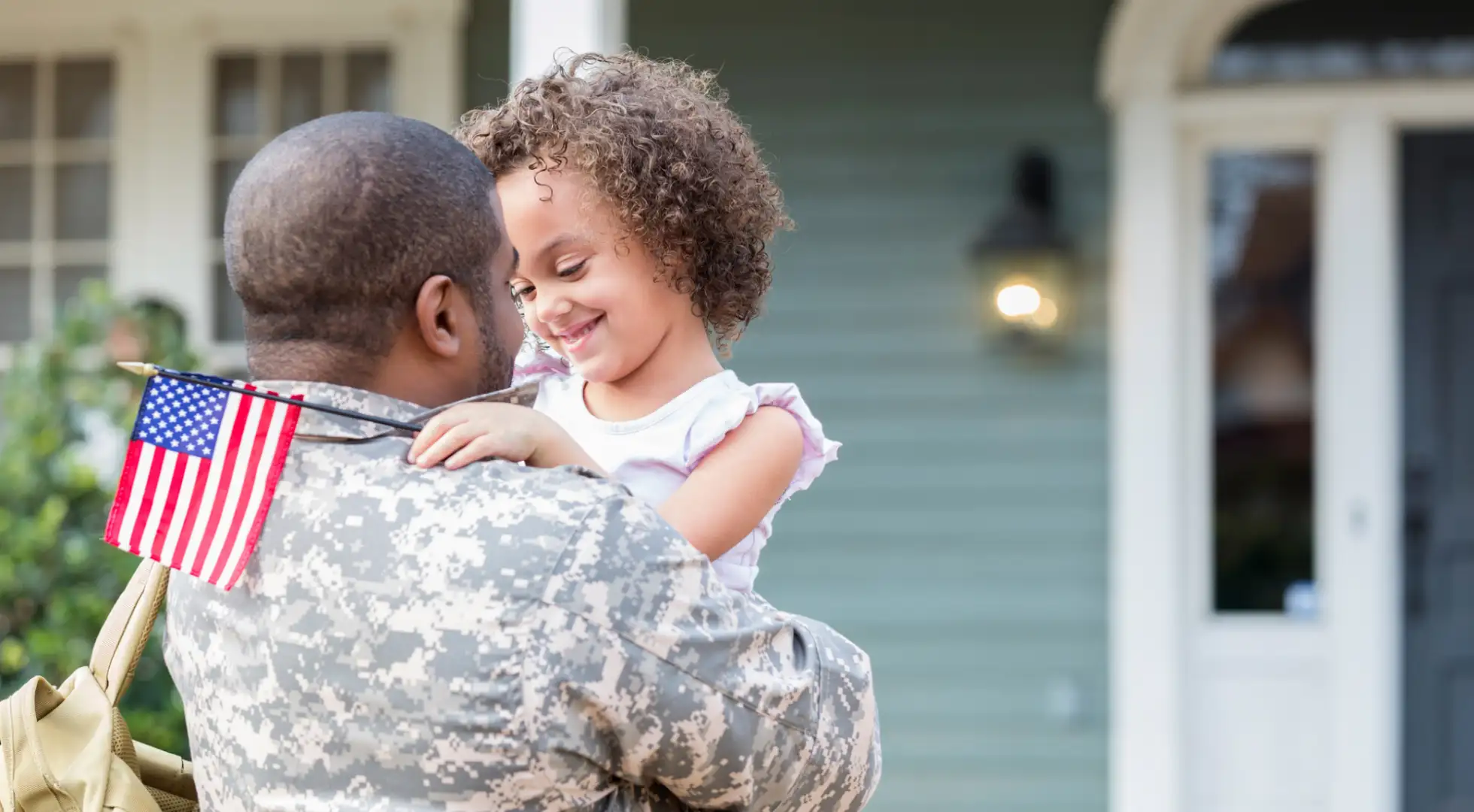 Soldier with kid in front of house