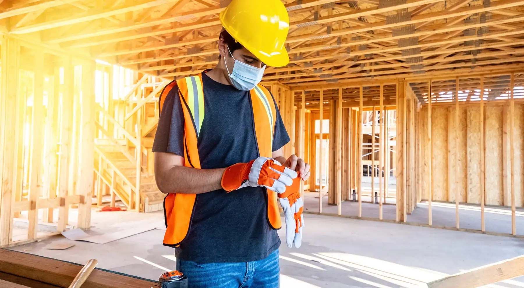 Young male construction worker wearing a protective face mask.