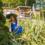 New homeowner gardening in front of a manufactured home in a rural setting