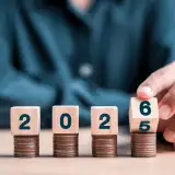 A hand flipping dice to 2026