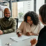 homebuying couple signing paperwork at closing