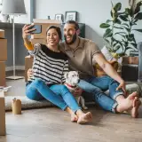 couple taking a photo in their new phone: buying a home you can keep