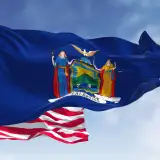 state flag of new york in front of united states flag