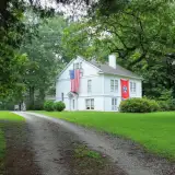 rural home in tennessee with both the US and state flags: down payment assistance