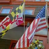 maryland and us flags in front of a home: down payment assistance