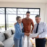 couple looking over a contract with their real estate agent in a high-rise condo