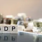 "GDP" spelled out with Scrabble tiles on desk.