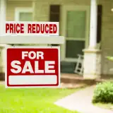 home for sale sign with price reduction