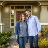 Couple standing in front of a house. Learn about student loan mortgage qualification guidelines.