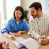 A couple sitting at a table, reviewing a mortgage document with an advisor.