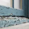Paint peels on the outside of a home.