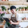 A self-employed florist learning about Fannie Mae updates on a tablet in his flower shop.