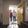 Black homebuyers walking through their front door.