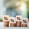Four stacks of coins with percentage signs on top of them, representing interest rates on mortgage loans