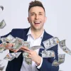 A man throwing 100 dollar bills