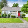 House exterior with a red door and nice yard