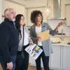 Real estate agent showing a couple the interior of a house that's for sale.