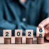 A hand flipping dice to 2026