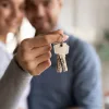 Young couple holding keys: cash wedding gifts for a down payment