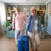 couple with luggage walking into their vacation home