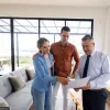 couple looking over a contract with their real estate agent in a high-rise condo