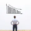 person looking at a bar chart trending downwards: mortgage rates