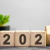A hand flipping dice to 2027