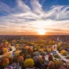 Aerial view of a suburban neighborhood backdropped by a setting sun.