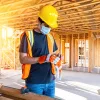 Young male construction worker wearing a protective face mask: mortgage rates