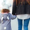 Child holding their parent's hand walking down the street